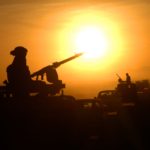 An Italian soldier is shown on lookout duty at sunset.