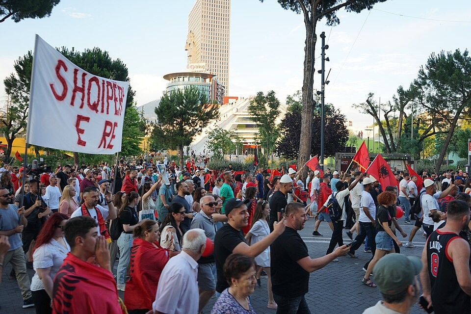 Corteo di manifestanti con bandiere albanesi e lo striscione «Shqipëri e re» sul viale Dëshmorët e Kombit a Tirana