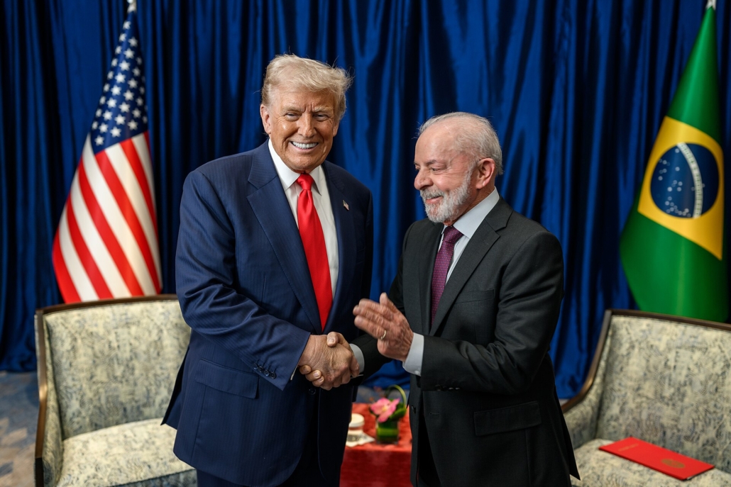 Donald Trump e Lula si stringono la mano davanti alle bandiere di Stati Uniti e Brasile